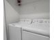 Bright laundry room with a GE washer and dryer and a wire rack shelf at 1565 Plunker Dr, Davenport, FL 33896