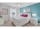 Bedroom with a white bed, vibrant accent wall, and stylish bedside tables at 1578 Slice Way, Davenport, FL 33896