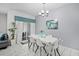 Bright dining area featuring modern chandelier, sleek white table, and sliding door to patio at 1578 Slice Way, Davenport, FL 33896