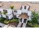An elevated angle of a well maintained townhome shows a private entryway, well manicured landscaping, and a tile roof at 1578 Slice Way, Davenport, FL 33896