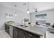 Open kitchen and living room, featuring granite countertops, stainless appliances, and modern design at 1578 Slice Way, Davenport, FL 33896