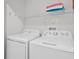 Practical laundry room with washer, dryer, and upper shelf storage at 1578 Slice Way, Davenport, FL 33896