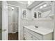 Bright bathroom with a white vanity, decorative mirror, and tiled walls at 16 Pine Forest Dr, Haines City, FL 33844
