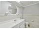 Well-lit bathroom featuring tiled walls, a large mirror, and vanity sink at 16 Pine Forest Dr, Haines City, FL 33844