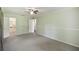 Light filled bedroom showcases a ceiling fan, neutral carpeting, a closet, and ensuite bathroom access at 16 Pine Forest Dr, Haines City, FL 33844