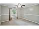 Cozy bedroom featuring neutral carpet, a ceiling fan, and a large window at 16 Pine Forest Dr, Haines City, FL 33844