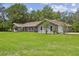 Beautiful single story home with large front lawn, mature trees, and attached side-entry garage at 16 Pine Forest Dr, Haines City, FL 33844