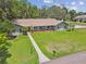 Aerial view of the attractive single-story home with a beautifully manicured lawn and mature landscaping at 16 Pine Forest Dr, Haines City, FL 33844