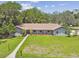 Manicured front lawn with walkway leads to this home's charming covered porch and red front door at 16 Pine Forest Dr, Haines City, FL 33844