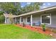 Inviting front porch with brick flooring, rocking chairs, and fresh landscaping at 16 Pine Forest Dr, Haines City, FL 33844