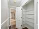 Hallway closet with white shelving provides efficient storage solutions and contributes to an organized living space at 16 Pine Forest Dr, Haines City, FL 33844