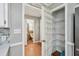 Kitchen view with a large closet featuring white shelving, leading to the powder room and stainless steel appliances at 16 Pine Forest Dr, Haines City, FL 33844