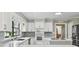 Modern kitchen with stainless steel appliances, hardwood floors, white cabinets, quartz countertops, and tiled backsplash at 16 Pine Forest Dr, Haines City, FL 33844