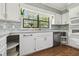 This kitchen features white cabinets, quartz countertops, stainless appliances, tiled backsplash, and hardwood floors at 16 Pine Forest Dr, Haines City, FL 33844