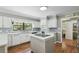Bright kitchen featuring white cabinets, hardwood floors, tiled backsplash, kitchen island, and stainless steel appliances at 16 Pine Forest Dr, Haines City, FL 33844