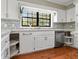 This kitchen features white cabinets, quartz countertops, hardwood floors, and a large window at 16 Pine Forest Dr, Haines City, FL 33844