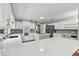 Bright kitchen features white cabinets, island with cooktop, hardwood floors, quartz countertops and stainless steel appliances at 16 Pine Forest Dr, Haines City, FL 33844