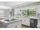 Bright kitchen features white cabinets, stainless steel dishwasher, and an induction cooktop on the island at 16 Pine Forest Dr, Haines City, FL 33844