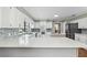 Spacious kitchen with white cabinets, an island cooktop, stainless steel appliances, quartz countertops, and hardwood floors at 16 Pine Forest Dr, Haines City, FL 33844