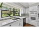 Modern kitchen featuring white cabinets, quartz countertops, stainless appliances, tiled backsplash, and hardwood floors at 16 Pine Forest Dr, Haines City, FL 33844