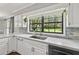 Bright kitchen featuring stainless steel appliances, white cabinets, backsplash and a window overlooking the backyard at 16 Pine Forest Dr, Haines City, FL 33844