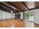 Spacious living room features a stone fireplace, wood beam ceiling, and hardwood floors at 16 Pine Forest Dr, Haines City, FL 33844