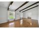 Spacious and bright living room with wood floors, ceiling beams, and large windows offering a comfortable setting at 16 Pine Forest Dr, Haines City, FL 33844