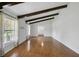 Living room featuring wood floors, large windows, and ceiling beams provides ample space for entertaining at 16 Pine Forest Dr, Haines City, FL 33844