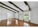 Bright and open living room features wood floors, ceiling beams, and large windows for a welcoming atmosphere at 16 Pine Forest Dr, Haines City, FL 33844