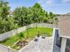 Aerial view of backyard showing a large grassy area, stone patio with furniture, string lights and privacy fence at 1600 Spray Ter, St Cloud, FL 34771