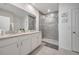 Bathroom with granite countertop vanity, framed mirrors, and a glass-enclosed shower at 1600 Spray Ter, St Cloud, FL 34771