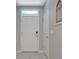 An interior view of an entryway with a white front door, tile floor, and neutral gray walls at 1600 Spray Ter, St Cloud, FL 34771