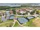 Aerial view featuring tennis courts, swimming pool, and beautiful landscaping on a sunny day at 16049 Volterra Pt, Bella Collina, FL 34756