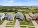 Aerial view of a beautiful gray home with a two-car garage, complemented by lush greenery at 16049 Volterra Pt, Bella Collina, FL 34756