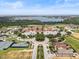 Beautiful aerial shot of the community near a lake, with tennis courts, pool, and luxurious villas at 16049 Volterra Pt, Bella Collina, FL 34756
