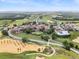 Panoramic aerial shot showcasing the community, golf course, and surrounding landscape under a clear sky at 16049 Volterra Pt, Bella Collina, FL 34756