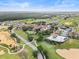 Community aerial view featuring manicured lawns, swimming pool, tennis courts, and scenic green spaces at 16049 Volterra Pt, Bella Collina, FL 34756
