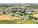 An aerial view showcasing golf course, tennis courts, pool, and luxurious landscaping at 16049 Volterra Pt, Bella Collina, FL 34756