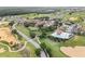 An aerial view showcases tennis courts and a large pool set amidst lush green golf courses at 16049 Volterra Pt, Bella Collina, FL 34756