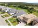 An aerial view of new construction homes with an attractive lush green wooded area backdrop at 16049 Volterra Pt, Bella Collina, FL 34756
