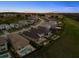 An aerial view showing the property, surrounding homes, and lush green landscape beyond at 16049 Volterra Pt, Bella Collina, FL 34756