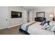 Bedroom with a dark wood dresser, wood-look floors, and a tv on the wall at 16049 Volterra Pt, Bella Collina, FL 34756