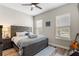 Bedroom with a gray bed frame, wood-look floors, and natural light from two windows at 16049 Volterra Pt, Bella Collina, FL 34756
