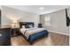 Bedroom with a dark wood bed frame, wood-look floors, and a chair at 16049 Volterra Pt, Bella Collina, FL 34756