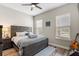 Inviting bedroom with a wooden bed frame, soft bedding, and two bright windows at 16049 Volterra Pt, Bella Collina, FL 34756
