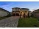 Charming two-story home featuring a manicured lawn and a long driveway with a two car garage at 16049 Volterra Pt, Bella Collina, FL 34756
