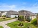 Beautifully landscaped homes with manicured lawns, palm trees and long driveways with two car garages at 16049 Volterra Pt, Bella Collina, FL 34756