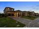 Charming two-story home featuring a manicured lawn and a long driveway with a two car garage at 16049 Volterra Pt, Bella Collina, FL 34756