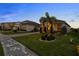 Beautifully landscaped home with manicured lawn, palm trees and long driveway with a two car garage at 16049 Volterra Pt, Bella Collina, FL 34756