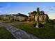 Stunning home featuring lush landscaping, a brick-paved driveway, and elegant architectural details at 16049 Volterra Pt, Bella Collina, FL 34756